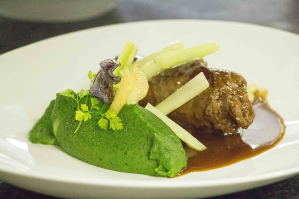 Rindsroulade mit B&auml;rlauchp&uuml;ree und Garnierung.
